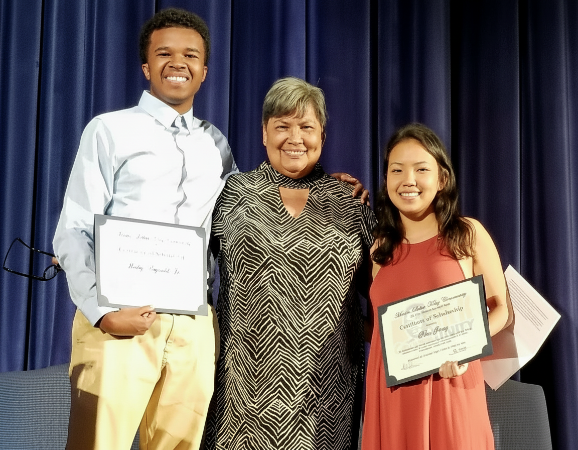 Scholarship award recipients with presenter on stage